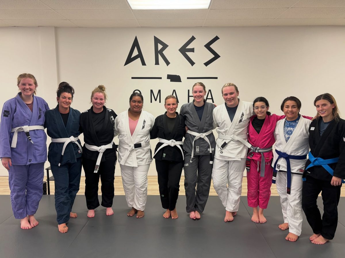 Women's class group photo at the Ares BJJ Omaha wall