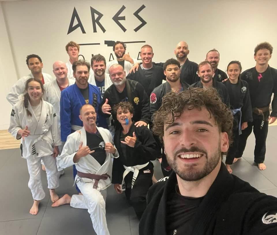 The adult Brazilian Jiu-Jitsu class gathered together on the mats after training at Ares BJJ Omaha